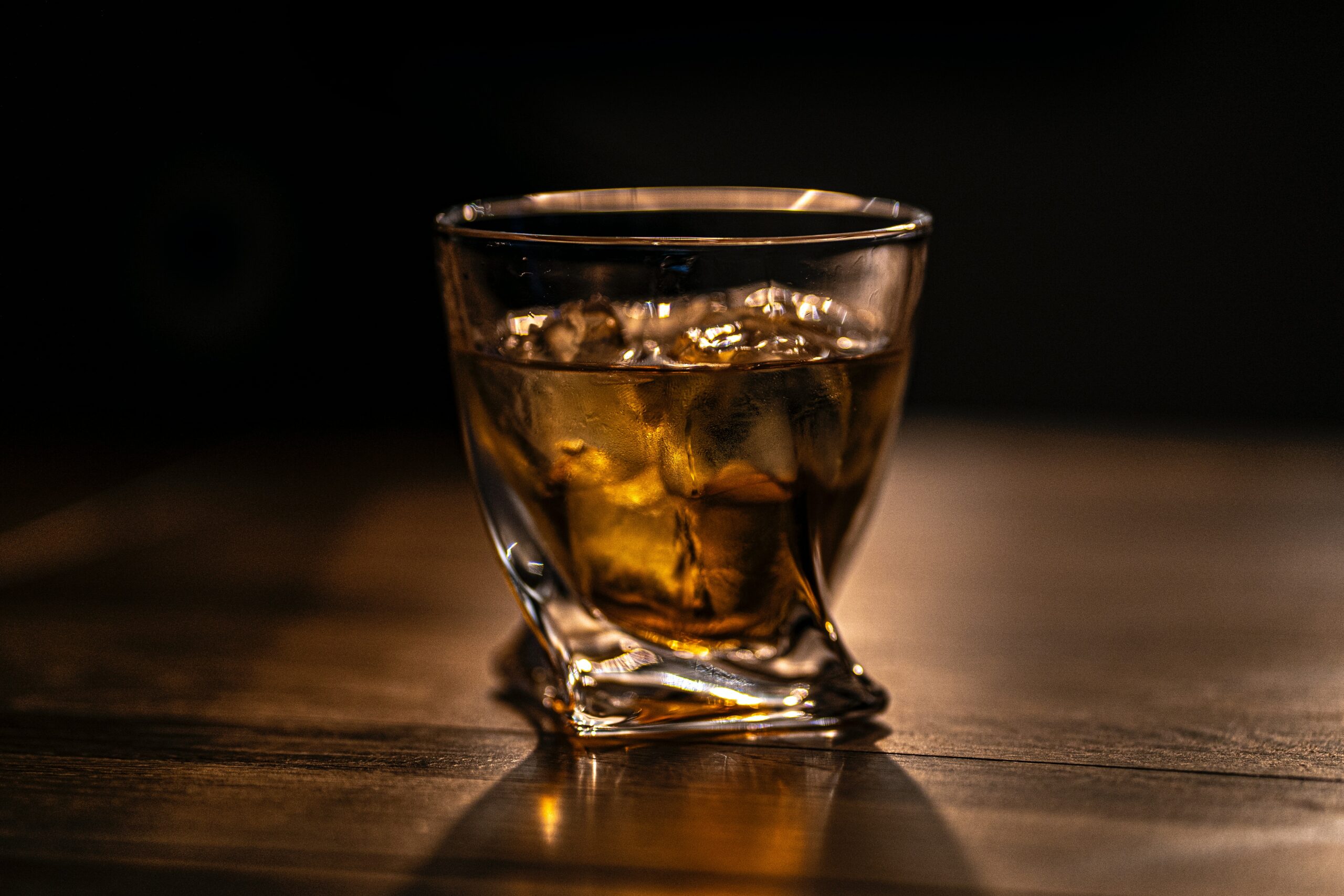 Whisky glas med isterninger og whisky i.
